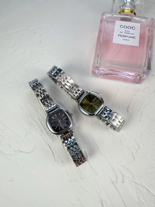 Flat lay view of NAIDU square dial ladies watches in black and green with silver metal bands