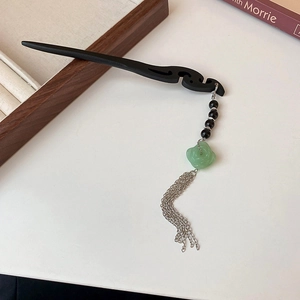 Dettaglio della forcina in legno con fiore di finta giada verde e nappe in argento