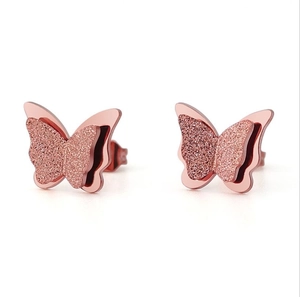 Rose gold butterfly stud earrings with matte and polished wings in close-up detail