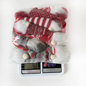 Gnome plush Christmas ornaments weighing 98g on digital scale with striped knitted detail