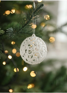 Detailed close-up of a white hollowed-out Christmas ball ornament with sparkling glitter