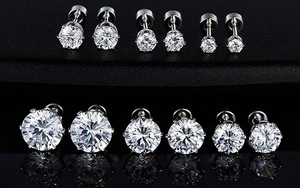 Macro shot of 18k gold plated six-prong zircon stud earrings in various sizes with reflection