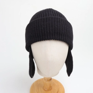 Detail view of the black knit ear protection hat showing vertical ribbed texture