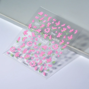 3D floral nail stickers with pink flower embossing and green leaves on white background