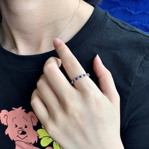Detail of S925 silver eternity ring with alternating blue sapphire and white diamonds