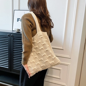 Detail of chunky knit cream shoulder bag showing textured diamond pattern and soft fabric