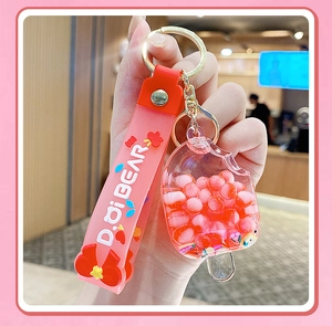 Close-up of cute pink popsicle keychain with silicone wrist strap and liquid glitter