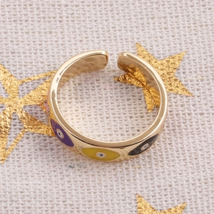 Gold-plated Evil Eye open ring with colorful enamel detailing on beige fabric background