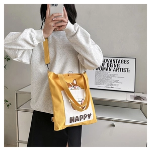 Detail of yellow canvas bag featuring a cute Corgi cartoon print and adjustable strap