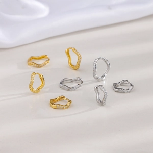 Detailed view of wave-shaped earrings with micro-pave zircons in gold and silver