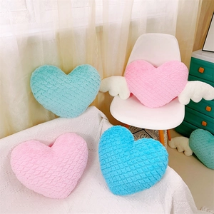 Gros plan de coussins en peluche douce en forme de cœur avec ailes rose et bleu