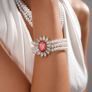 Detailed macro view of baroque multi-layer pearl bracelet with red gemstone floral clasp