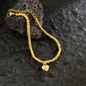 Polished 18K gold titanium steel heart bracelet with shimmering twisted chain texture