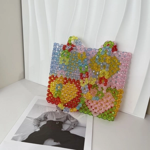 Detailed close-up of handmade colorful heart-pattern beaded tote bag with vibrant textures