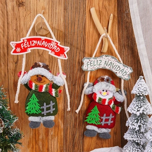 Close-up of reindeer and snowman fabric ornaments with Feliz Navidad banner on wood wall