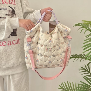 Quilted elephant canvas bag with purple handles and pink strap shown in a lifestyle setting
