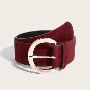 Détail de la ceinture en daim bordeaux avec boucle fer à cheval dorée élégante