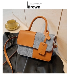 Detail of a brown leather and grey wool crossbody bag with a fashion hanging tag