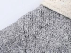 Close-up of high-quality grey knit fabric texture and shoulder stitching detail