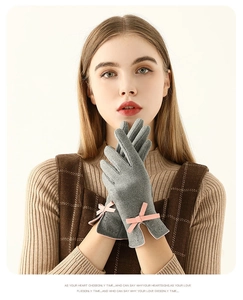 Détail de gants d'hiver gris avec un nœud rose et un tissu thermique doux