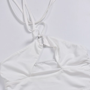 Detail of white halter neck top with metallic ring and ruched fabric texture