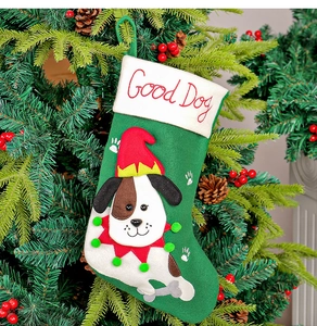 Dettaglio calza di Natale verde in feltro con ricamo Good Dog su albero addobbato