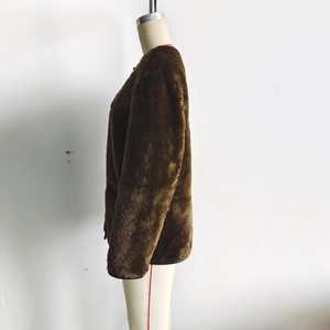 Detailed side profile of brown faux fur jacket sleeve and hem on a display mannequin