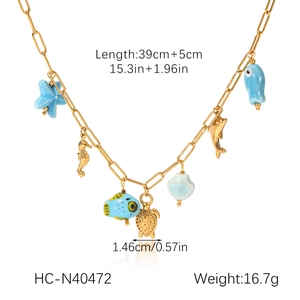 Détail du collier marin avec pendentifs hippocampe doré et étoile de mer bleue