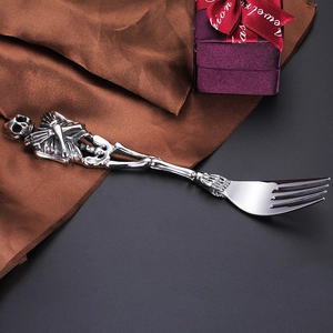 Macro detail of gothic skull handle design on stainless steel fork with luxury gift box