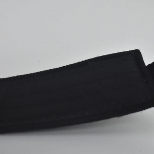 Detail of black fabric visor with reinforced stitching and adjustable velcro strap