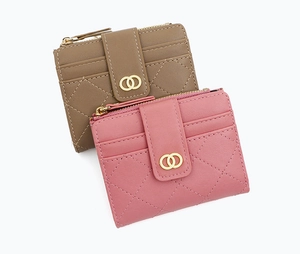 Detail of quilted women's wallet with metal buckle and top zipper in pink and khaki colors
