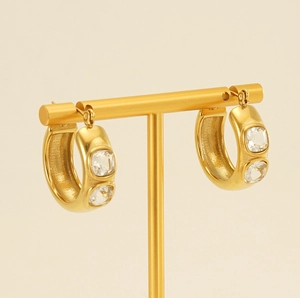 Macro shot of 18K gold plated thick hoop earrings with square zircon on a jewelry stand