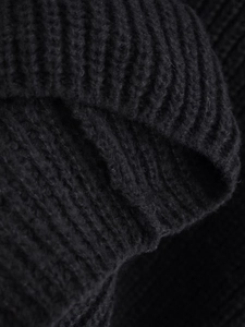 Dettaglio della trama in maglia grossa nera con motivi intrecciati del maglione