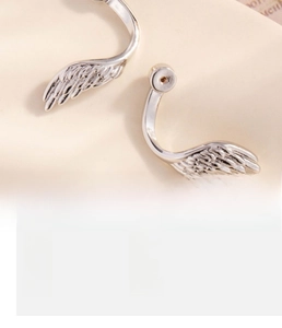 Detailed view of silver copper wing earrings showing intricate feather texture and size