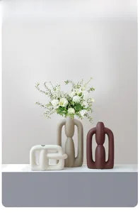 Detail of matte ceramic vases set with abstract geometric shapes and human form aesthetics