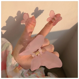 Detail of matte pink butterfly hair clips set including one claw and two side clips