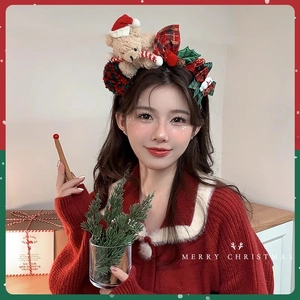 Cute Christmas bear headband with red green plaid bow and holly leaf sequins on model