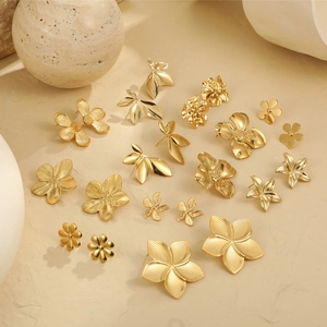 Detailed top view of gold floral stud earrings in matte and polished finishes