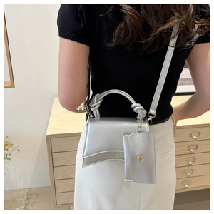 Détails du sac sablier argenté brillant avec poignée nouée et mini pochette assortie