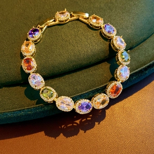 Close-up of gold vintage bracelet with multi-colored gemstones and zircon borders