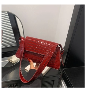 Close-up of a red crocodile pattern PU leather shoulder bag with fine embossed details