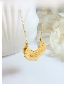 Detail showing the irregular hammered texture on a 18K gold-plated stainless steel necklace