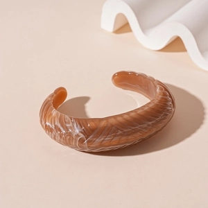Detail of vintage acrylic cuff with marble texture and grooved surface on artistic prop