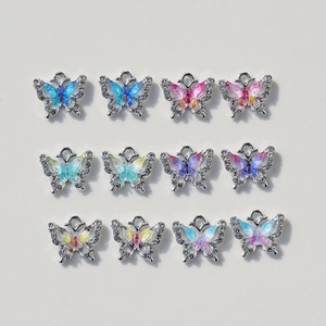 Macro shot of 12 butterfly pendants with colorful gradient wings and zircon inlays