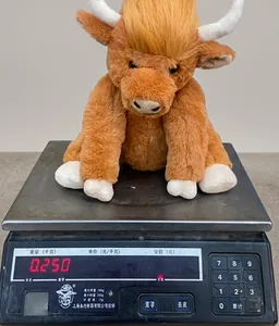 Detailed view showing the weight of a brown Highland Cow plush toy on a digital scale
