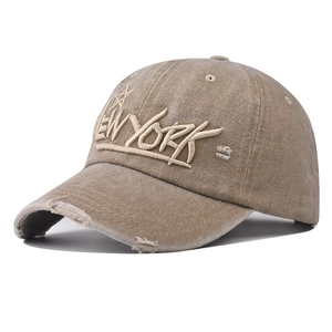 Detail of distressed brim and New York embroidery on washed cotton baseball cap