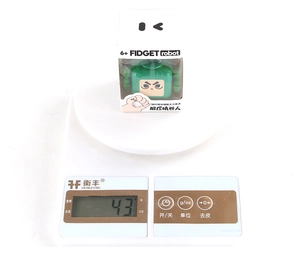 Macro di un robot giocattolo antistress verde del peso di 43g nella confezione