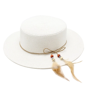 Detail of white straw sun hat with brown rope band and bohemian feather pendant decoration