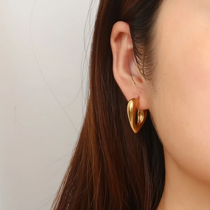 Elegant 18k gold plated stainless steel hollow heart earrings worn by a model
