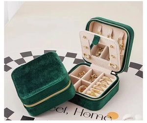 Close-up of portable emerald velvet jewelry box with mirror, hooks and ring slots